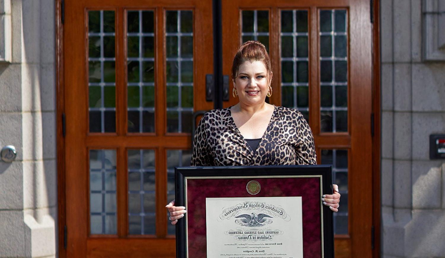 Dina Coughlan holding her diploma